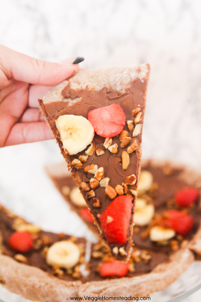 This recipe for Nutella pizza includes a homemade dough, Nutella, chopped nuts, and fresh fruit as toppings.